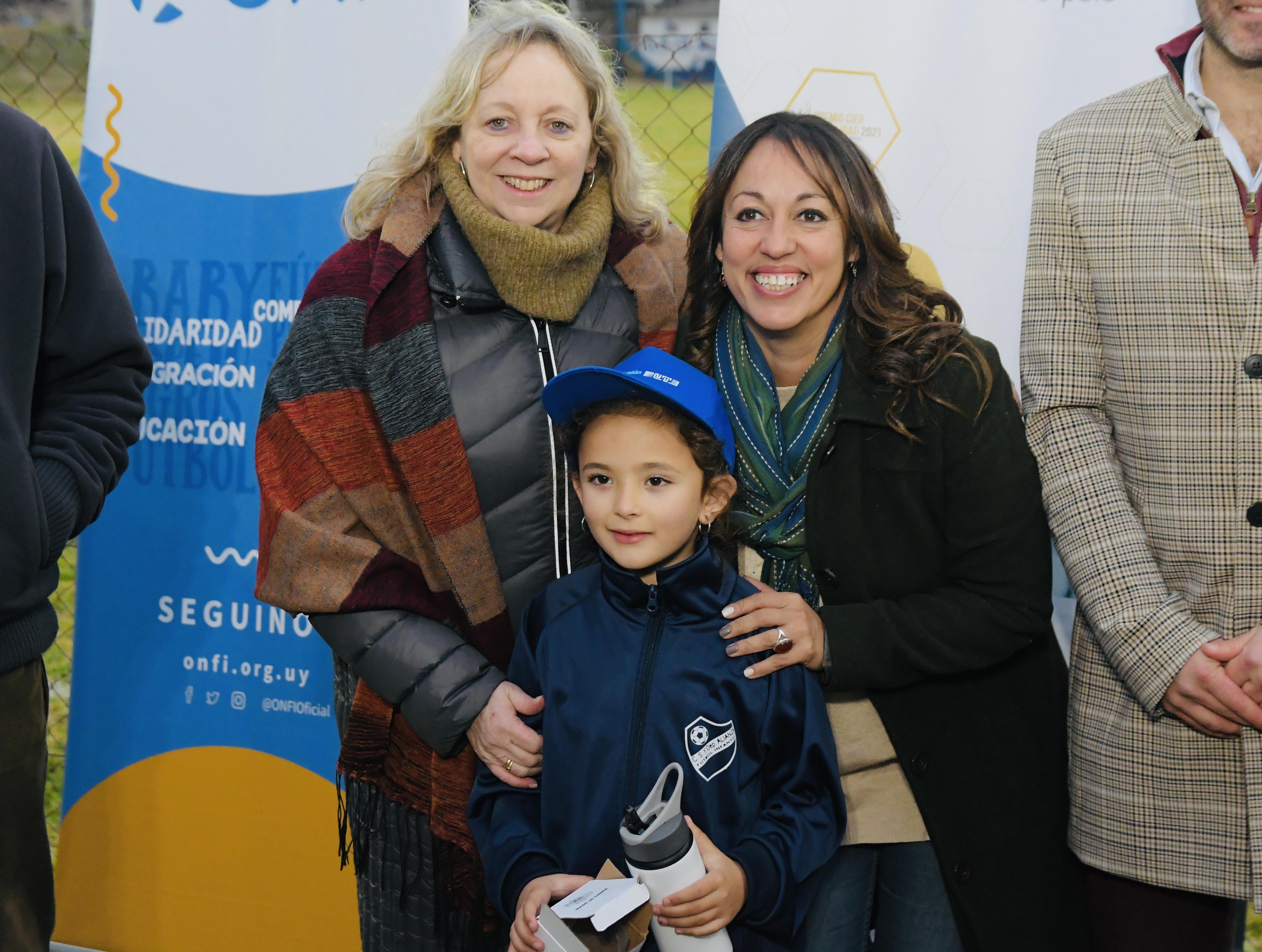 Silvia Emaldi y Fernanda Cardona junto a una niña jugadora de futbol infantil